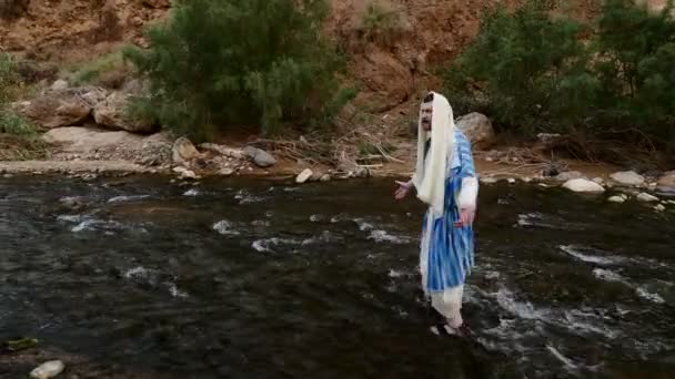 Ein Mann in jüdischem Gewand ist im Fluss, hebt die Hände zum Himmel. — Stockvideo