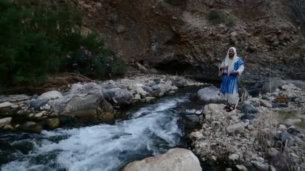 Judío saltando sobre una roca en el río . — Vídeos de Stock