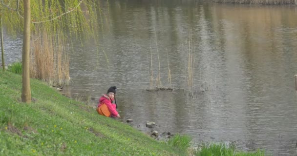 Little Girl Observes of a Water Flow in River — Stock Video