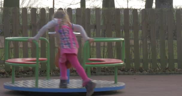 Menina joga sozinho em um parque infantil — Vídeo de Stock