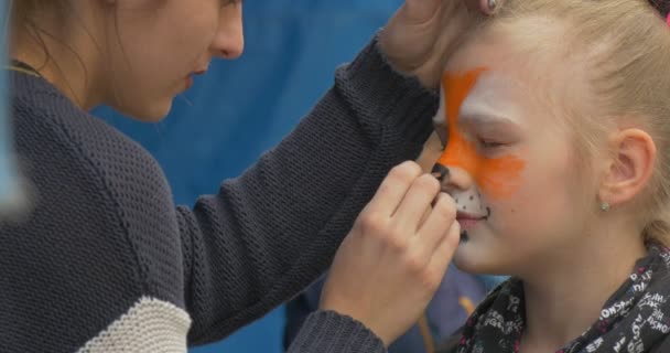 Dítě čelí malbu na festivalu. — Stock video