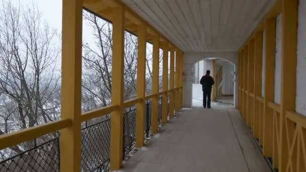 En man går på den långa terrassen. — Stockvideo