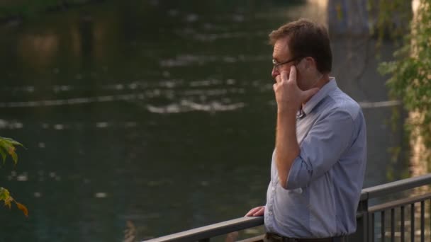 Pria Dewasa Memakai Kacamata Berbicara Smartphone Dekat Danau — Stok Video