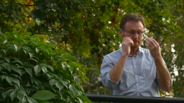 Ein erwachsener dunkelhaariger Mann setzt seine Brille auf — Stockvideo