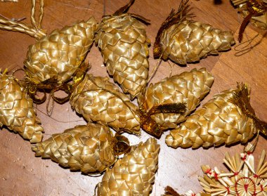 Yukarıdan yakın plan bir çekim. Çam kozalağı şeklinde dekoratif Noel süslemeleri koyu ahşap bir yüzeye serilmiştir..