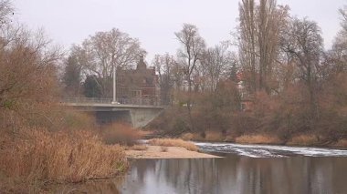 Arka planda köprüsü olan sakin bir nehrin panoramik görüntüsü