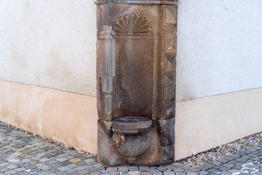 Bir mimari detayın yakın çekimi: aşınma belirtileri gösteren açık renkli bir binanın köşesi,