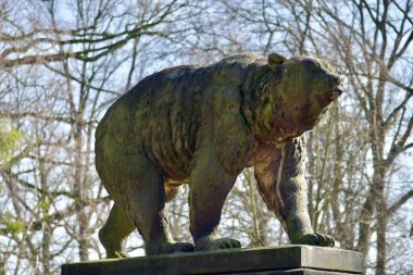 Ağaçların arasındaki parkta gerçek boyutta kahverengi ayı heykeli..