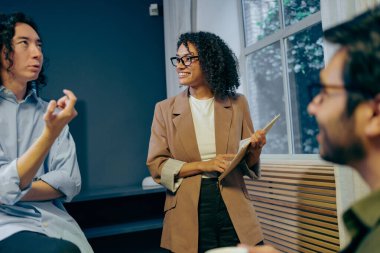 Modern ofiste küçük takım toplantısı, proje yönetmeliği notları meslektaşlarını animasyon tartışmasına çekiyor,