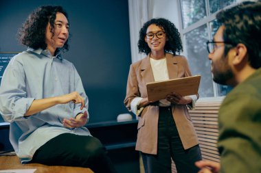 istemci başarı yöneticisi proje önerisi sunuyor, dizini tutuyor, gülümsüyor ve hissedarları meşgul ediyor,