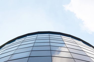 Mavi gökyüzü ve arka planında bulutlar olan modern bir bina. Düzenlemeden sonra.