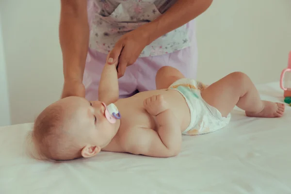 Massagista fazendo massagem um pequeno bebê . — Fotografia de Stock