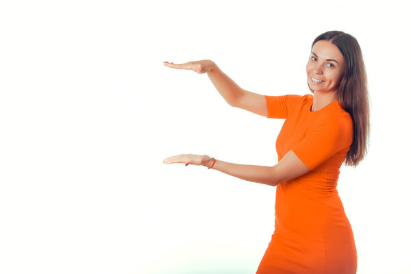 Девушка в красном платье на белом фоне показывает руку
.