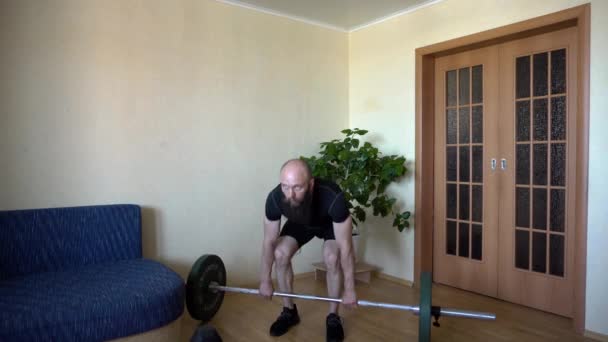 Homem atlético forte em t-shirt e shorts fazendo exercício de barra. — Vídeo de Stock