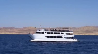 Yolcuları denizde olan güzel beyaz bir yat..