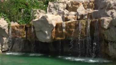 Su taşların üzerinden havuza akıyor.