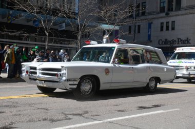 Toronto, ON, Kanada - 12 Ekim 2025: Beyaz antika bir acil durum aracı kaldırımdan izleyicilerin izlediği bir geçit töreninde şehir caddesinde ilerliyor.