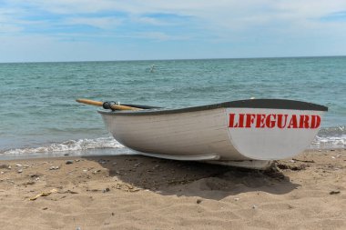 Toronto, ON, Kanada - 12 Ekim 2025: Beyaz bir cankurtaran botu denizin yanındaki çakıllı bir sahilde, güvenlik görevine hazır..