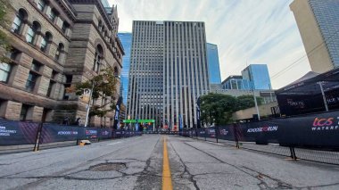 Toronto, ON, Kanada - 18 Ekim 2025: Yarış engelleri olan boş bir şehir caddesi uzun bir ofis kulesinin önünde maratonun önünde duruyor.