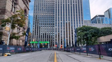 Toronto, ON, Kanada - 18 Ekim 2025: Yarış engelleri olan boş bir şehir caddesi uzun bir ofis kulesinin önünde maratonun önünde duruyor.