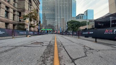 Toronto, ON, Kanada - 18 Ekim 2025: Yarış engelleri olan boş bir şehir caddesi uzun bir ofis kulesinin önünde maratonun önünde duruyor.