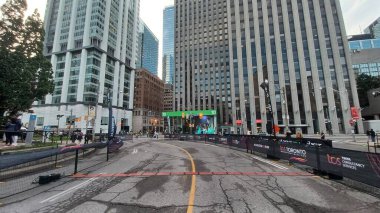 Toronto, ON, Kanada - 18 Ekim 2025: Yarış engelleri olan boş bir şehir caddesi uzun bir ofis kulesinin önünde maratonun önünde duruyor.