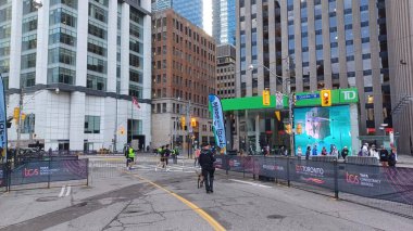 Toronto, ON, Kanada - 18 Ekim 2025: Bir polis memuru ve K9 birimi köpeği şehir maratonu başlamadan önce boş, kapalı cadde rotasında devriye geziyorlar.