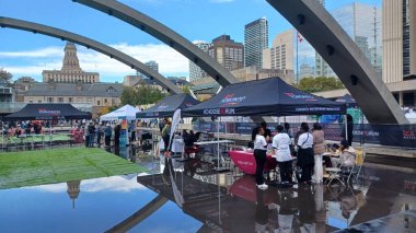 Toronto, ON, Kanada - 18 Ekim 2025: Bir belediye binasının sembolik kemerleri, satıcı çadırlarıyla düzenlenen bir maraton etkinliği sırasında bir havuza yansıyor