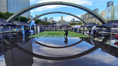 Toronto, ON, Kanada - 18 Ekim 2025: Bir belediye binasının sembolik kemerleri, satıcı çadırlarıyla düzenlenen bir maraton etkinliği sırasında bir havuza yansıyor