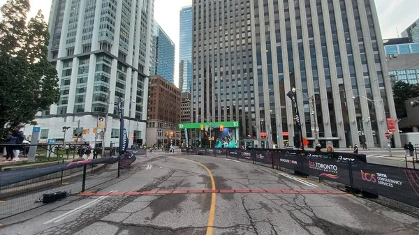 Toronto, ON, Kanada - 18 Ekim 2025: Yarış engelleri olan boş bir şehir caddesi uzun bir ofis kulesinin önünde maratonun önünde duruyor.