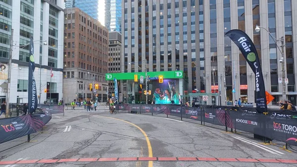 Toronto, ON, Kanada - 18 Ekim 2025: Yarış engelleri olan boş bir şehir caddesi uzun bir ofis kulesinin önünde maratonun önünde duruyor.