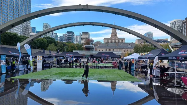 Toronto, ON, Kanada - 18 Ekim 2025: Bir belediye binasının sembolik kemerleri, satıcı çadırlarıyla düzenlenen bir maraton etkinliği sırasında bir havuza yansıyor