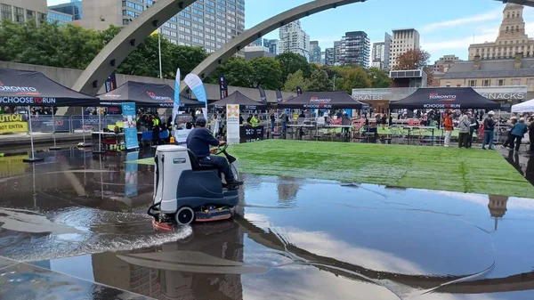 Toronto, ON, Kanada - 18 Ekim 2025: Bir belediye binasının sembolik kemerleri, satıcı çadırlarıyla düzenlenen bir maraton etkinliği sırasında bir havuza yansıyor