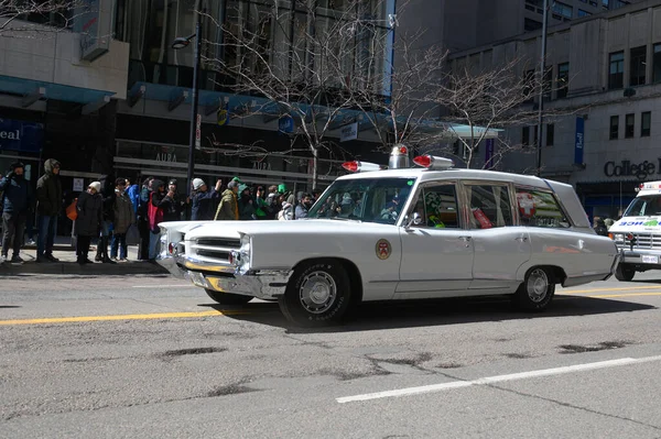 Toronto, ON, Kanada - 12 Ekim 2025: Beyaz antika bir acil durum aracı kaldırımdan izleyicilerin izlediği bir geçit töreninde şehir caddesinde ilerliyor.