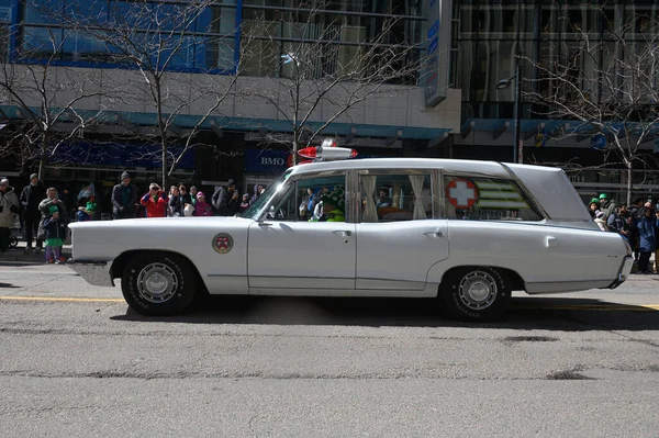 Toronto, ON, Kanada - 12 Ekim 2025: Beyaz antika bir acil durum aracı kaldırımdan izleyicilerin izlediği bir geçit töreninde şehir caddesinde ilerliyor.