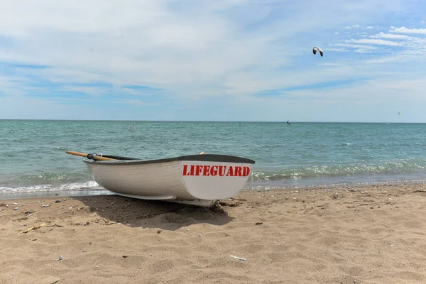 Toronto, ON, Kanada - 12 Ekim 2025: Beyaz bir cankurtaran botu denizin yanındaki çakıllı bir sahilde, güvenlik görevine hazır..