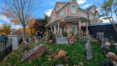 Toronto, ON, Kanada - 22 Ekim 2025: Bir ön bahçe büyük bir evin önünde ayrıntılı cadılar bayramı süslemeleri içerir.