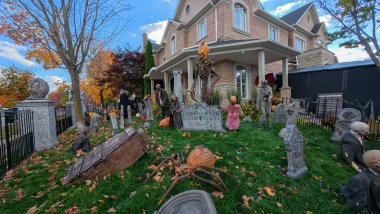 Toronto, ON, Kanada - 22 Ekim 2025: Bir ön bahçe büyük bir evin önünde ayrıntılı cadılar bayramı süslemeleri içerir.