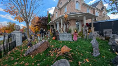 Toronto, ON, Kanada - 22 Ekim 2025: Bir ön bahçe büyük bir evin önünde ayrıntılı cadılar bayramı süslemeleri içerir.