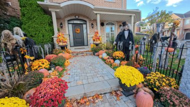 Toronto, ON, Kanada - 22 Ekim 2025: Bir ön bahçe büyük bir evin önünde ayrıntılı cadılar bayramı süslemeleri içerir.