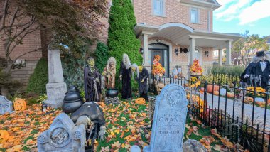 Toronto, ON, Kanada - 22 Ekim 2025: Bir ön bahçe büyük bir evin önünde ayrıntılı cadılar bayramı süslemeleri içerir.