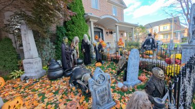 Toronto, ON, Kanada - 22 Ekim 2025: Bir ön bahçe büyük bir evin önünde ayrıntılı cadılar bayramı süslemeleri içerir.