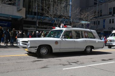 Toronto, ON, Kanada - 12 Ekim 2025: Beyaz antika bir acil durum aracı kaldırımdan izleyicilerin izlediği bir geçit töreninde şehir caddesinde ilerliyor.