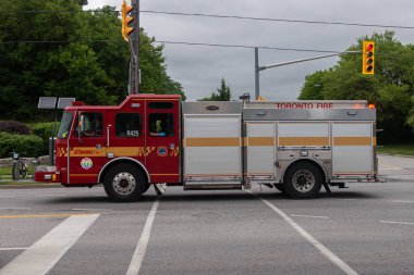 Toronto, ON, Kanada - 12 Ekim 2025: Parlak kırmızı bir Toronto İtfaiye aracı bir kavşağa doğru gidiyor..