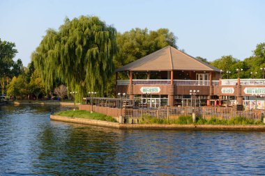 Toronto, ON, Kanada - 18 Ekim 2025: Güneşli bir günde bir rıhtım restoranı ve verandası suyun kenarında duruyor.