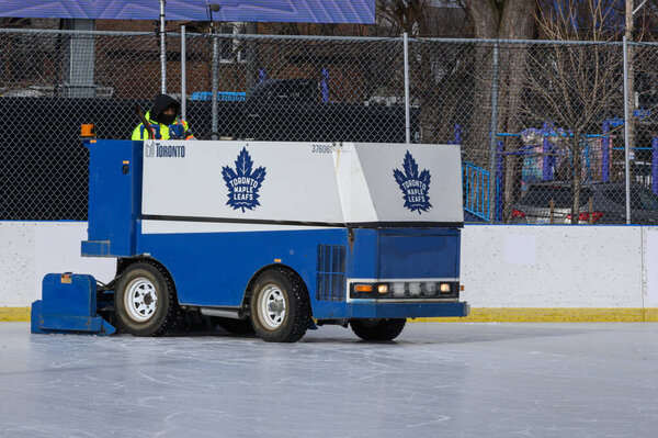 Торонто, Канада - 12 февраля 2025 года: Машина для восстановления льда Zamboni работает на открытом хоккейном катке под пустыми трибунами.