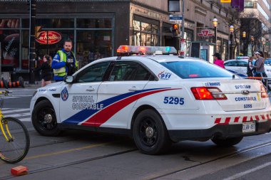 Toronto, ON, Kanada - 24 Ekim 2025: Şehrin bir caddesinde parlayan acil durum ışıkları olan beyaz bir özel polis arabası durduruldu.