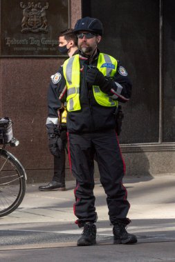 Toronto, ON, Kanada - 24 Ekim 2025: Arka planda Hudson 's Bay Company binasının bulunduğu finans bölgesinde bir Toronto polisi görev yapıyor.
