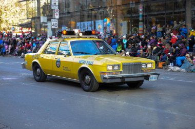 Toronto, ON, Kanada - 24 Ekim 2025: Klasik bir sarı metro polis arabası halka açık bir geçit töreninde şehir caddesinde ilerliyor.