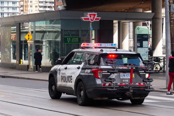 Toronto, ON, Kanada - 24 Ekim 2025: Parlayan acil durum ışıkları olan bir polis aracı şehir merkezindeki kavşakta duruyor.